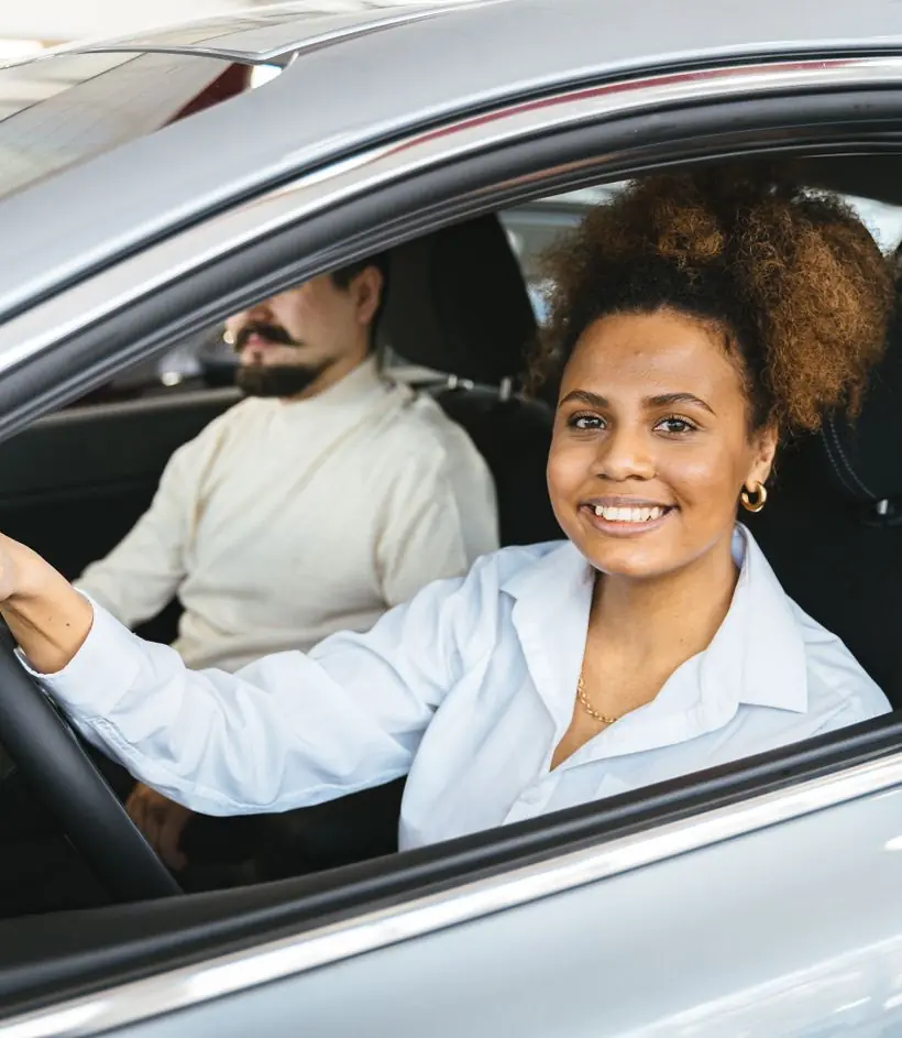 Mulher sorrindo ao volante do carro