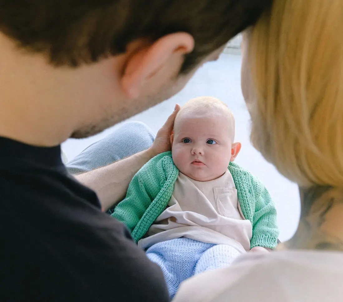 Pais segurando o bebê recém-nascido no colo